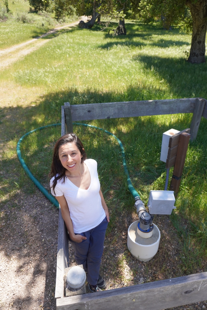 Perrone stands next to a groundwater well used to monitor natural conditions at the Jack and Laura Dangermond Preserve.